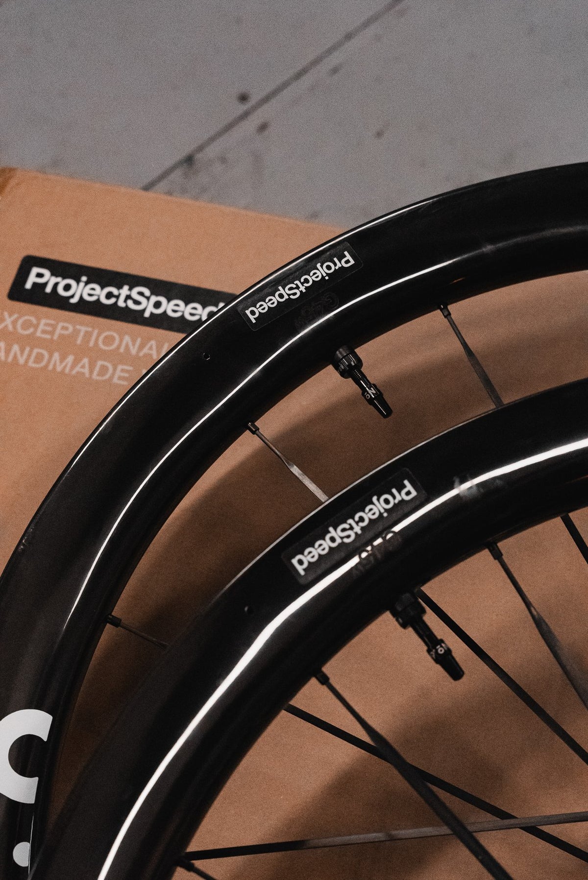 Pair of No.6 G45 gravel rims with ProjectSpeed labels, in front of a ProjectSpeed wheel box